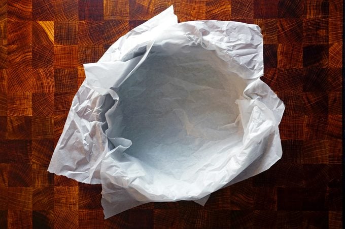 preparing a springform pan with parchment paper for basque cheesecake