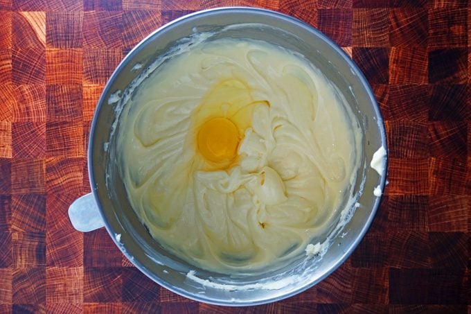 adding eggs to basque cheesecake filling mixture