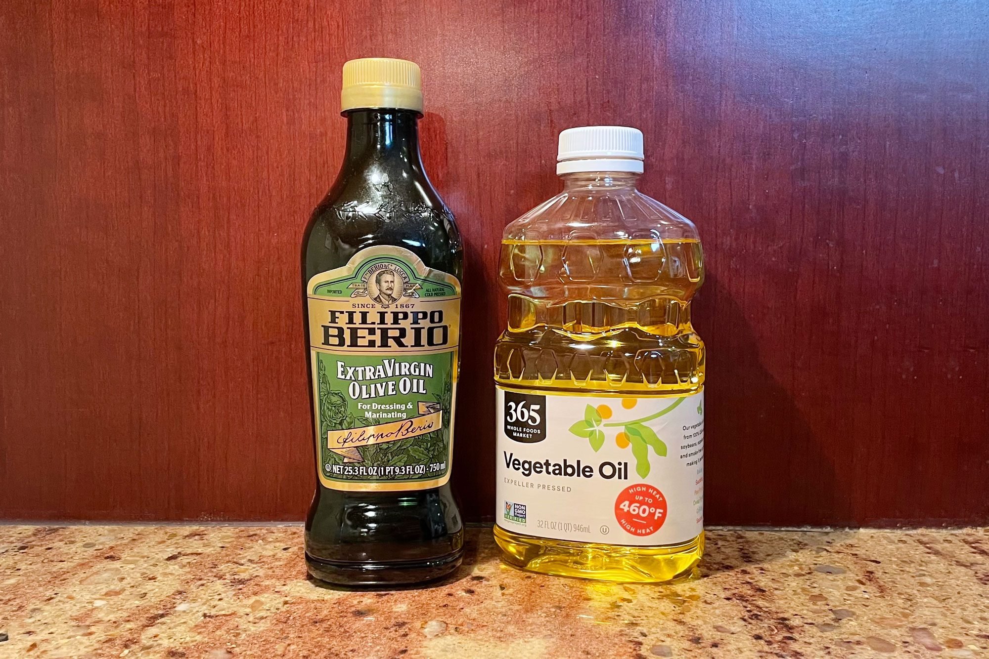 bottle of olive oil and a bottle of vegetable oil on a kitchen counter