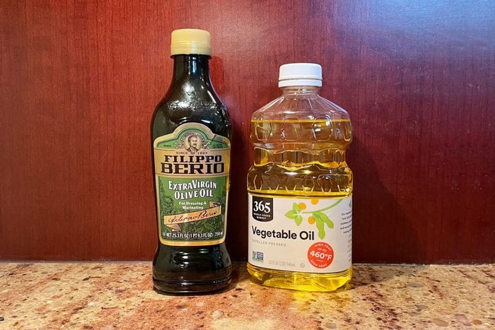 bottle of olive oil and a bottle of vegetable oil on a kitchen counter