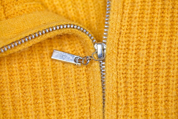 Close-Up Of stuck Zipper On yellow Sweater