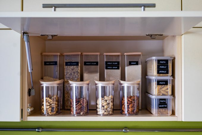 Domestic healthy vegetarian dry food storage organization on shelf at kitchen cupboard