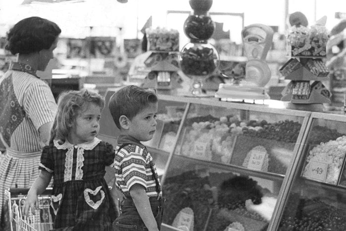 Mrs. C.F. Decker, 1745 S. Shoshone St., and her children, Cassandra, 4, and Brent, 3, think the candy is dandy in the Hested store display of Valentine's Day goodies; but wow! what a tough decision it poses. 