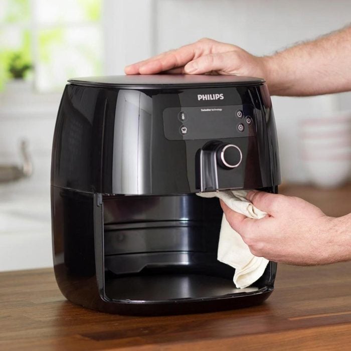 A Person Cleaning a Black Air Fryer