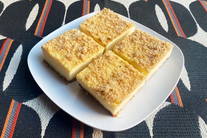 Creamy Pineapple Squares on white plate on retro tablecloth