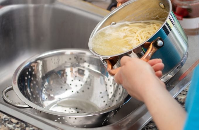 draining the water from the spaghetti