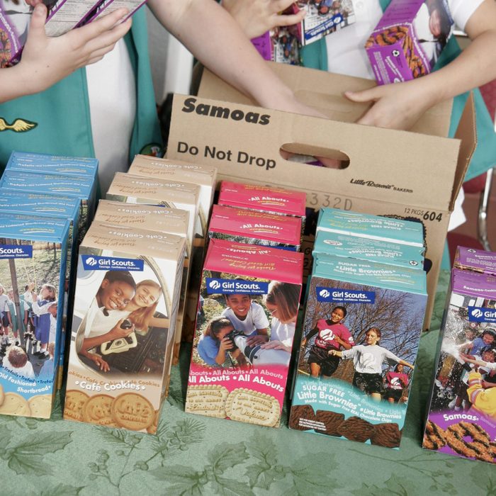 Girl Scouts selling boxes of cookies