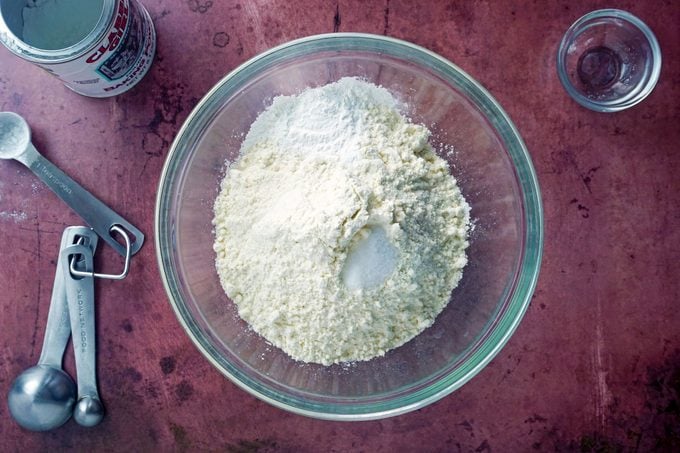 dry ingredients sifted together in a glass bowl on a purple background