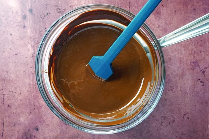 melted chocolate in a glass bowl on purple background