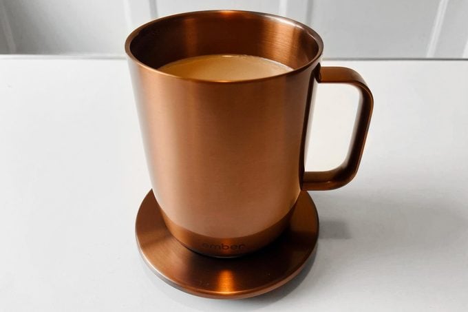 Copper colored Ember Mug On Coaster filled with coffee