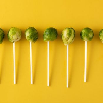 Set of brussel sprouts with lollipop sticks on yellow background