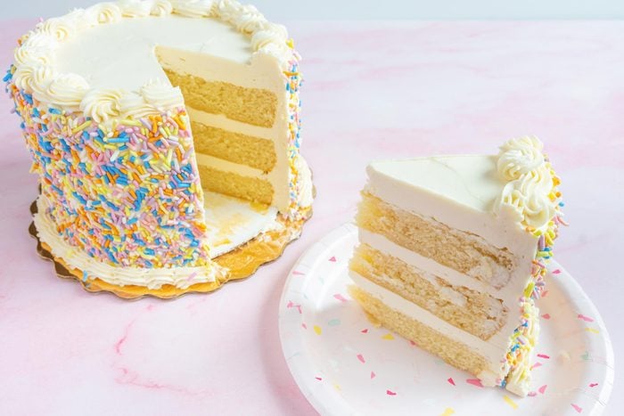 cake from whole foods with a slice cut from it on pink background