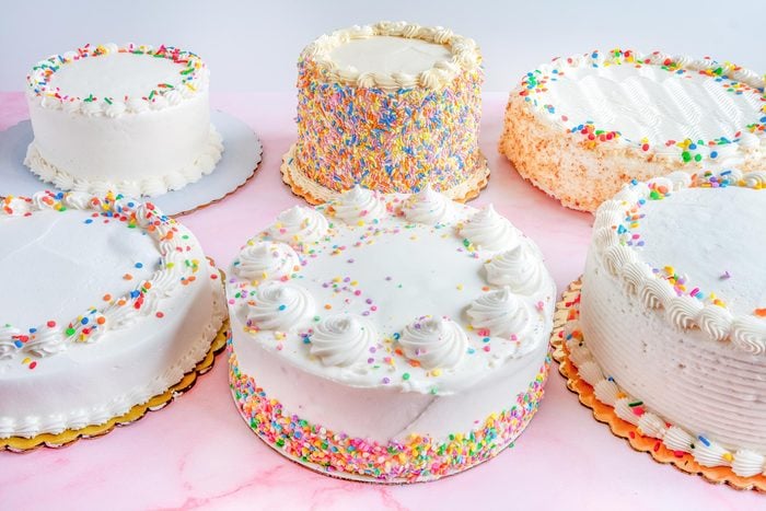 array of grocery store cakes on a pink background