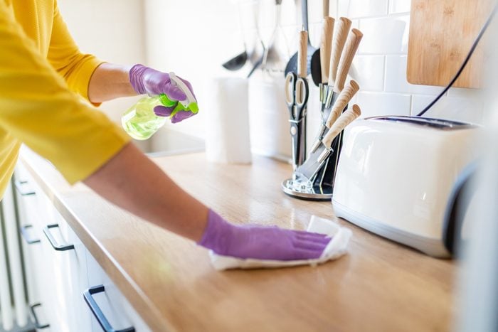 Hands in gloves cleaning kitchen counter