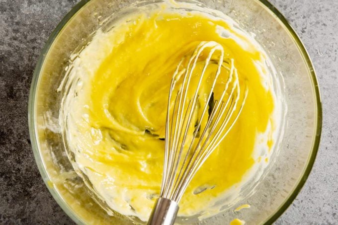 large glass mixing bowl with aioli and whisk