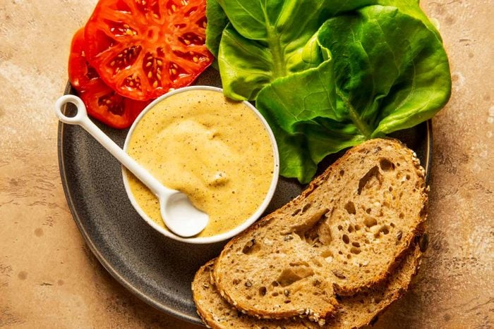 Dijon mustard on a plate with bread, lettuce and tomatoes