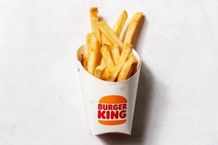 Burger King fries in cardboard cup with the Burger King logo, view from above on a white background