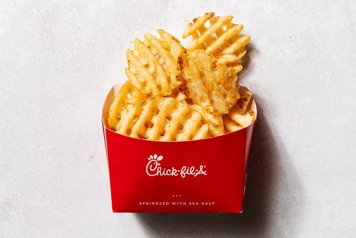 chick-fil-a waffle fries in a red cardboard cup with the logo, view from above on a white background