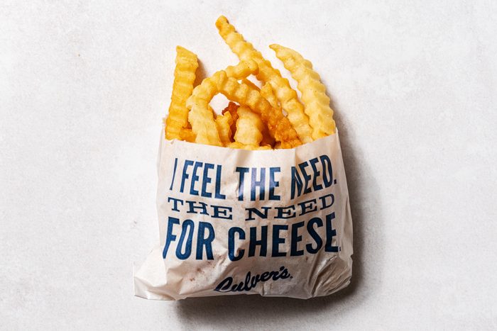 Culvers crinkle fries in a wax bag that says "feel the need for cheese" in blue letters