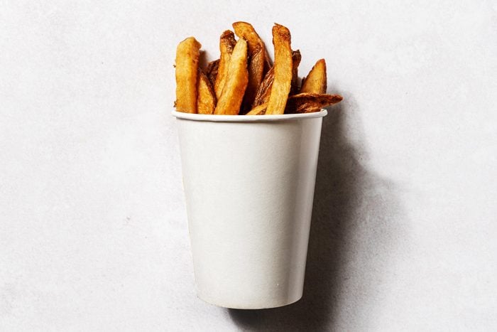 Fiveguys fries in an unbranded, white paper cup, on a white background