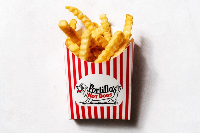 Portillos fries in a red and white portillos cardboard cup, on a white background