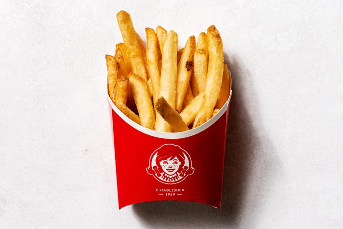Wendy's fries in a red Wendy's cardboard cup, on a white background