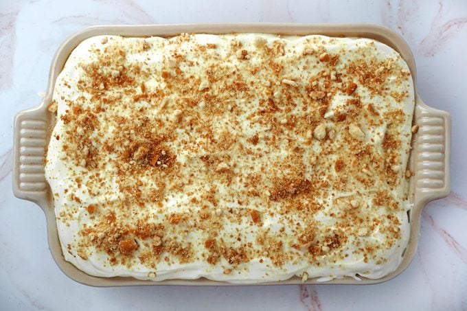 view from above of a Pan of banana cream pudding topped with whipped cream and crumbled vanilla wafer cookies