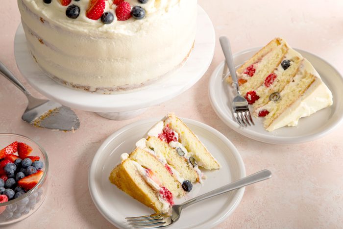 two slices of layered Chantilly cake on plates with forks