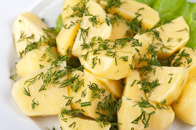 microwaved potato wedges with butter and dill for garnish