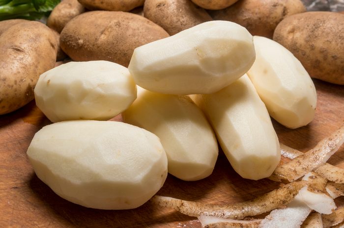 peeled potatoes on a cutting board