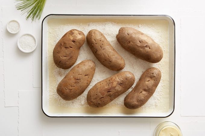 Still life of salt baked potatoes in roasting tin