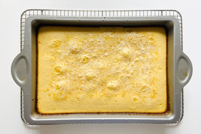 baked lemon bars on the pan and on a cooling rack