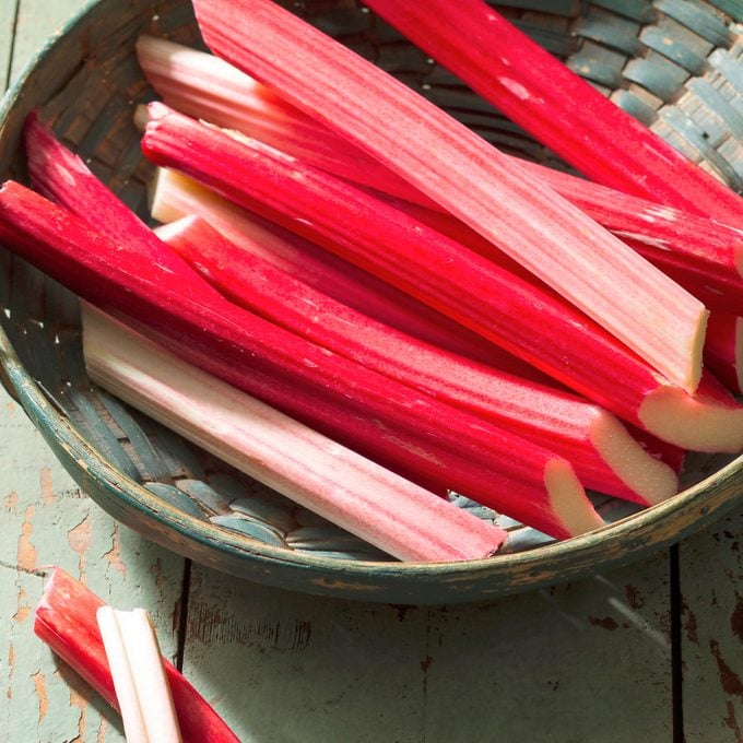 Rhubarb stalks in a basket on woodle table