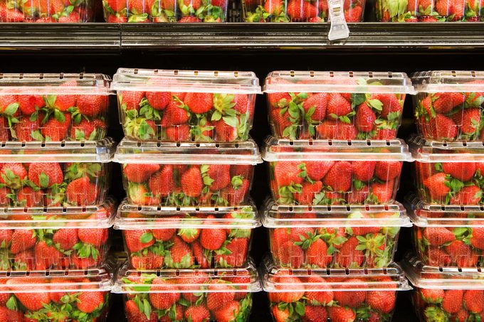 stacks of plastic strawberry containers in a grocery store