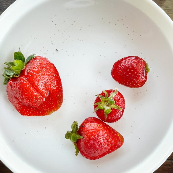 soaking strawberries in a bowl of salt water