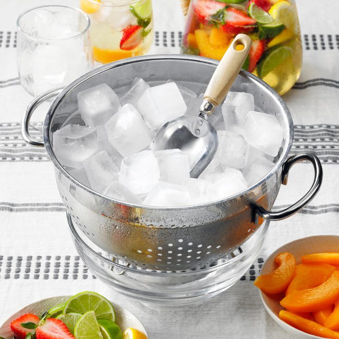 metal bucket with ice and scoop on a tablecloth