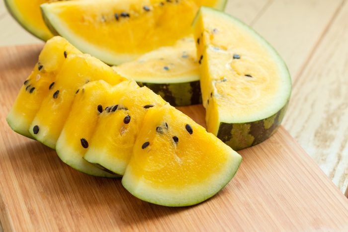 Yellow watermelon sliced on wooden background