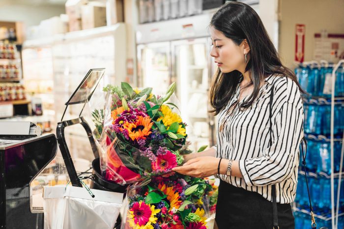 woman buying flowers at a grocery store