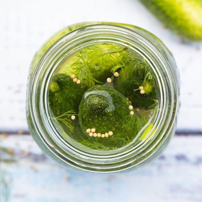 Overhead view of pickled dill pickles with mustard seeds