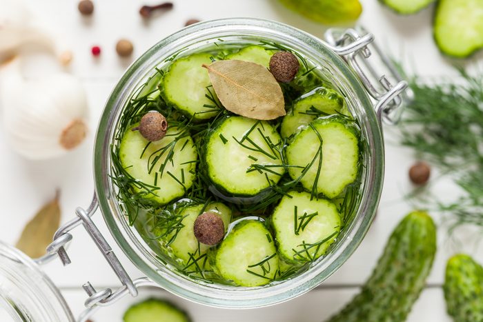 Pickled cucumbers closeup in a jar. Top view.