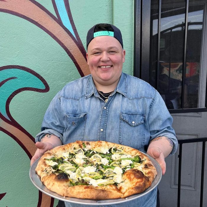 Red Sauce Pizza owner holding a pizza
