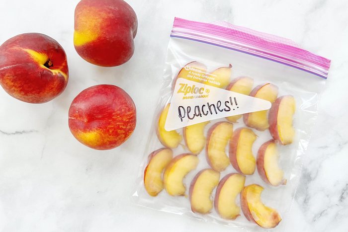 Frozen Peaches In Freezer Bag next to three fresh peaches