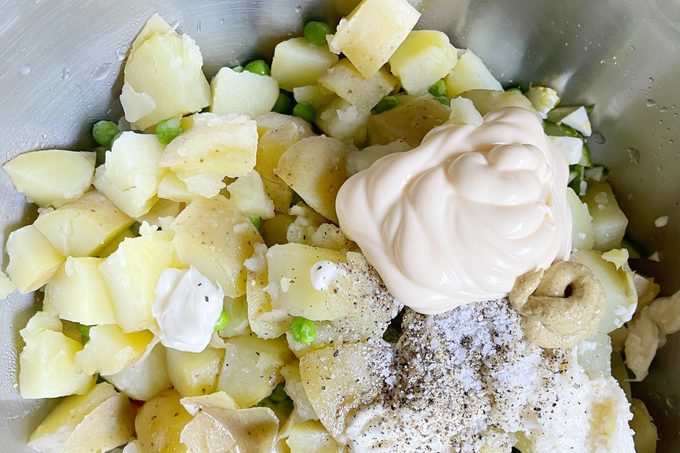 primo piano di ingredienti non miscelati in una ciotola per preparare insalata di patate hawaiana