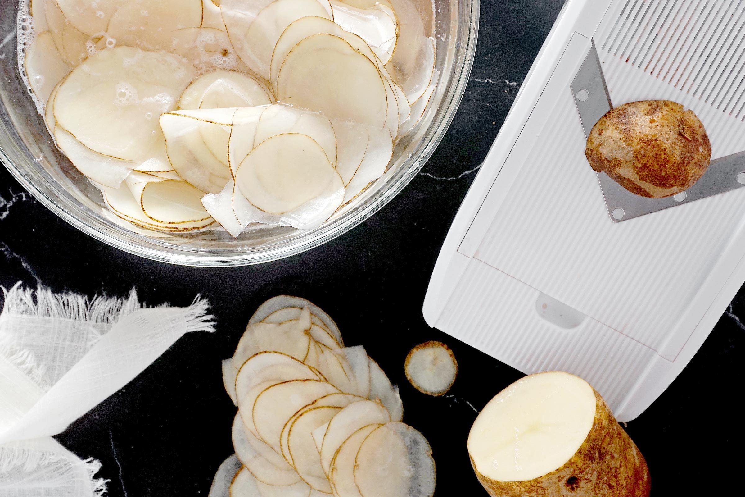 slicing potatoes into thin chips