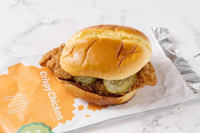 Mcdonald's chicken sandwich with its packaging on a white kitchen counter