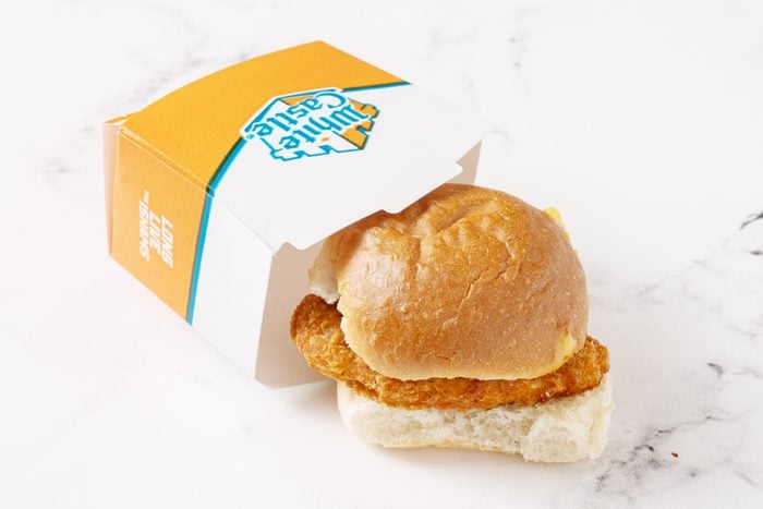 White Castle chicken sandwich next to its packaging on a white kitchen counter
