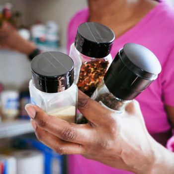 anonymous woman grabbing spices from the pantry