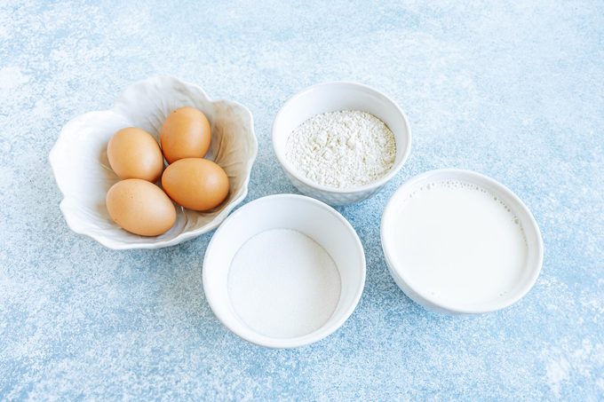 Ingredients for making a magic cake measured out into four small bowls