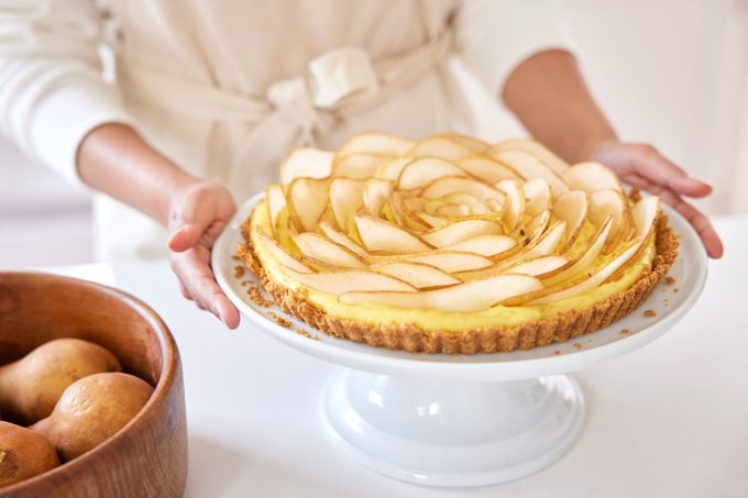 a finished pear tart on a cake stand