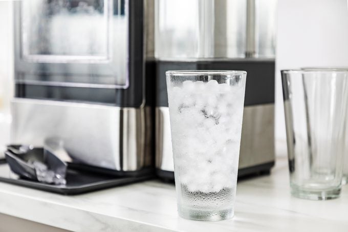 glass of ice water with the GE Profile Opal Nugget Ice Maker in the background